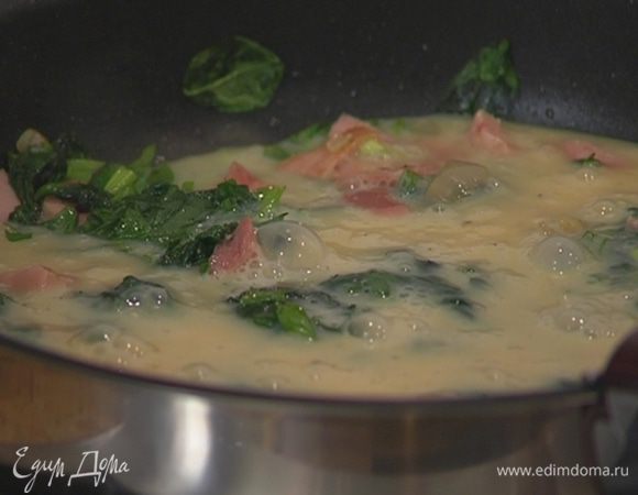 Яйца разбить в глубокую посуду, посолить, поперчить, перемешать и вылить в сковороду со шпинатом и ветчиной.