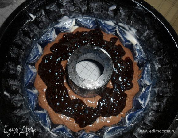 Форму для кекса смазать сливочным маслом и заполнить половиной теста. Затем ложкой разложить варенье, любое, у меня абрикосовое.