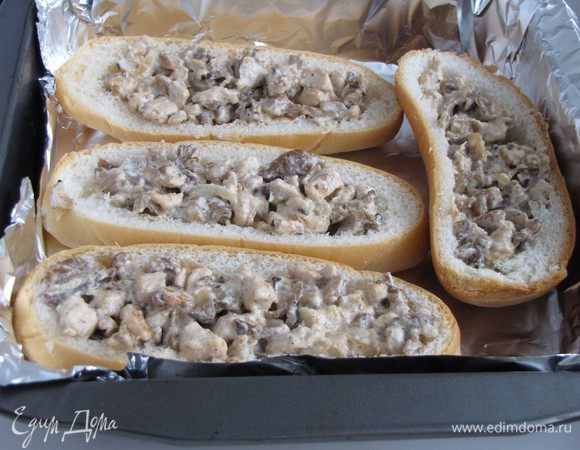 Багеты разрезать вдоль и вынуть мякиш. Заполнить начинкой и положить в форму для запекания, выстланную фольгой.
