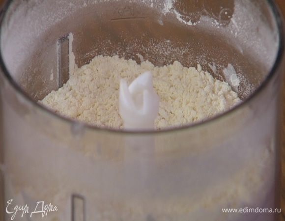 Предварительно охлажденное сливочное масло порезать небольшими кубиками и выложить в чашу блендера, всыпать 200 г муки, 1/4 ч. ложки морской соли и измельчить все в мелкую крошку.