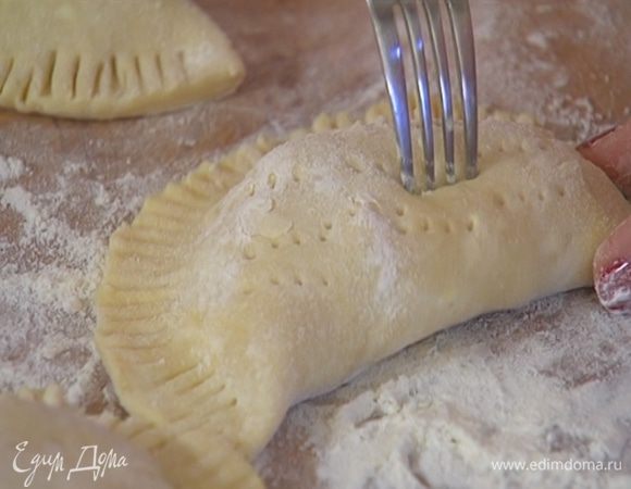 На одну половину каждого кружка выложить начинку, накрыть второй половиной и прижать края сначала руками, затем вилкой (неровные края можно срезать ножом). Слегка наколоть пирожки по всей поверхности вилкой.