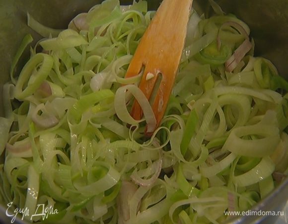 В кастрюлю с пореем добавить шалот и половину измельченного чеснока, все перемешать и обжаривать на медленном огне 3–4 минуты.