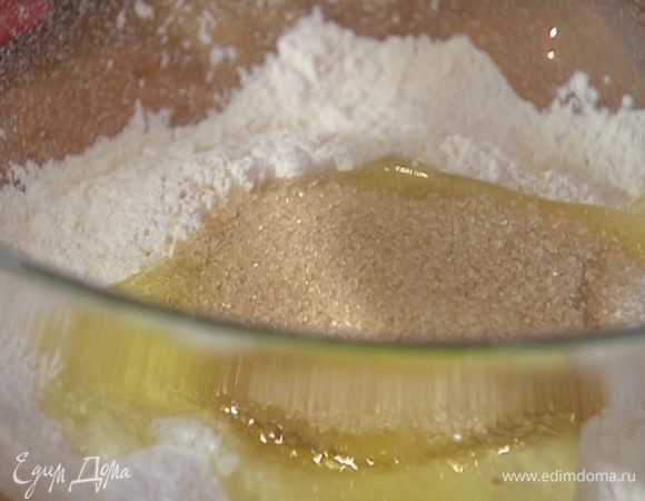 Сделать в муке углубление, разбить в него яйца, всыпать половину сахара и все перемешать.
