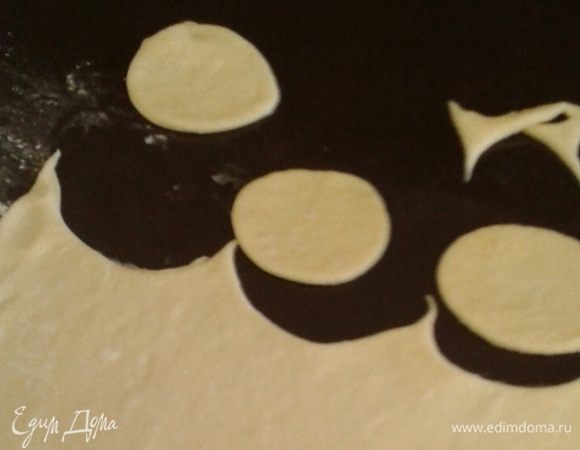 Затем подошедшее тесто делим на несколько частей. Раскатываем  пласт 2-3 мм, стаканом вырезаем кружки.