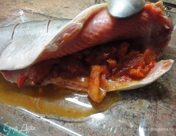 Подготовить заливку. В сковороде разогреть масло и в течении полуминуты обжаривать измельченный чеснок в тмином и паприкой. Добавить нарезанные кусочками помидоры и болгарский перец, влить сок от помидор. Я не солила, т.к. помидоры с соком были достаточно солеными. Довести до кипения и убрать с плиты. Часть овощей выложить в середину тушки.