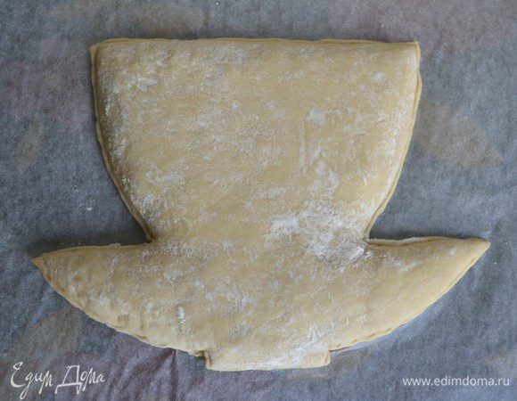 Раскатываем еще один овал и накрываем им заготовку с начинкой. Слегка прижимаем руками, чтобы была видна форма. Приложить сверху шаблон и еще раз вырезать. Края защипнуть. 
