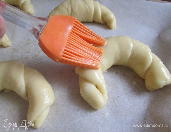 Рогалики выложить на противень, застеленной пекарской бумагой. Смазать рогалики яично-молочной смесью. Отправить рогалики в разогретую духовку (180 градусов), выпекать 25-30 минут. готовность проверить деревянной шпажкой.