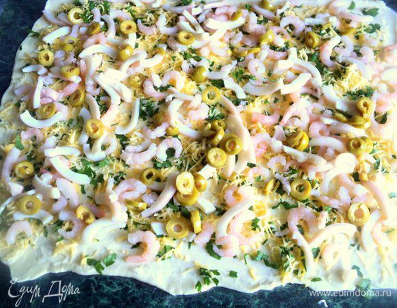 Сверху разложить морепродукты и оливки.