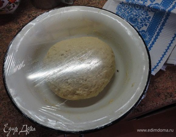 В углубление в муке вылить дрожжи, добавить кусочки размягченного масла, сахар, соль (в исходном рецепте соли не было, я тоже не добавляла, но когда попробовала готовый пирог, поняла, что соль все-таки нужна), цедру одного лимона, неполную чайную ложку кардамона, яйцо и оставшееся молоко. Тщательно перемешать, накрыть пищевой пленкой и полотенцем и оставить подходить в течение 1 часа.