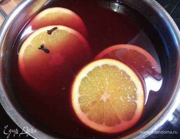 Ставим на огонь, добавляем нарезанный апельсин. Глинтвейн ни в коем случае нельзя доводить до кипения. При кипячении он моментально теряет свои вкусовые качества и большую долю содержания алкоголя. Как только пропала белая пена с поверхности вина, необходимо снять ёмкость с огня