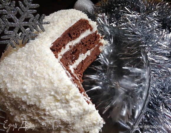 Мысленно делим крем на равные части по количеству коржей (у меня 3) + такая же часть на обмазку боков.
Вокруг нижнего коржа устанавливаем кольцо формы, распределяем по нему 1 часть крема - также поступаем со всеми остальными коржами (1 часть крема у вас должна еще остаться). Ставим торт в холодильник на ночь. Утром снимаем кольцо формы, обмазываем оставшимся кремом и присыпаем торт кокосовой стружкой (или классический вариант - какао).
Украшаем снежинкой (у меня декоративная, а можно сделать из белого или черного шоколада: растопить его, поместить в кондитерский шприц или кулек, нарисовать на пергаменте снежинку и дать ей застыть в холодильнике). Или притрусить какао под трафарет из снежинок.