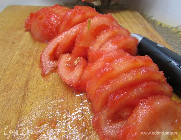Свежие помидоры надрезать крест накрест. Опустить в кипяток на несколько секунд. Затем снять кожицу и порезать полукольцами.