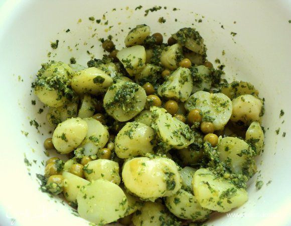 Картофель разрезать на половинки, добавить консервированный горошек и соус песто, перемешать. Посолить и поперчить по вкусу.