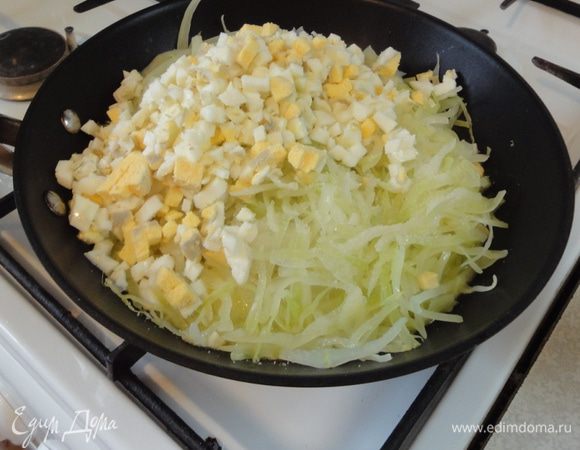 Готовим начинку. Капусту нашинковать, залить водой, довести до кипения. Откинуть на дуршлаг. В сковороде растопить сливочное масло, добавить капусту и нарезанные отварные яйца. Начинку прогреть и остудить.