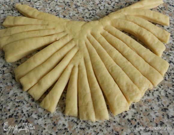 Меньшую разделить пополам. Одну часть раскатать и придать ей форму бороды, нарезать с помощью ножниц полосками, не доходя до верхнего края,

