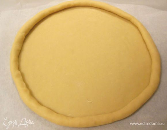 Пальцами плотно скатывать тесто по кругу от краёв к центру, пока диаметр не станет 25 см и сделать бортик 2 см высотой.