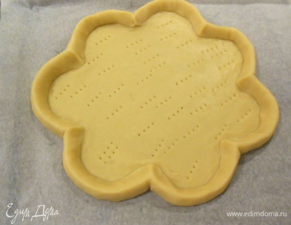  По размеченным на бумаге сегментам нужно сформировать 7 больших "лепестков". С помощью тупой стороны ножа сделать чёткие границы между фестонами. Вилкой несколько раз проколоть дно пирога и выпекать 25 минут или до золотистого цвета. Остудить на решётке.