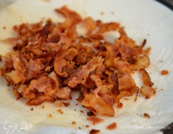 В небольшой емкости смешать изюм и белое вино. Разогреть духовку до 200 гр. Обжарить бекон на горячей сковороде до хруста. Переложить в блюдо с бумажным полотенцем. Дать остыть и поломать на кусочки.