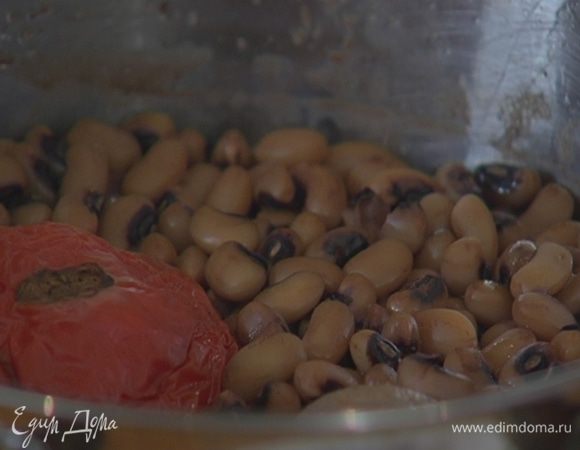 Залить фасоль свежей водой и отварить до готовности, добавив луковицу и помидор целиком, лавровый лист и черный перец (соль добавлять не нужно).