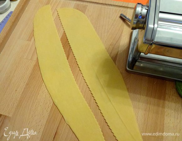 Тем временем, раскатываем тесто. Я не люблю раскатывать скалкой, просто не умею. Всегда пользуюсь машинкой для приготовления лапши. Между валиками податливое тесто очень легко раскатывается. Разделить на 2 части, разрезав по длине.