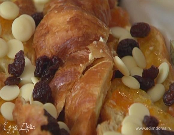 Выложить половинки круассанов в керамическую форму для выпечки, посыпать шоколадными каплями и изюмом.
