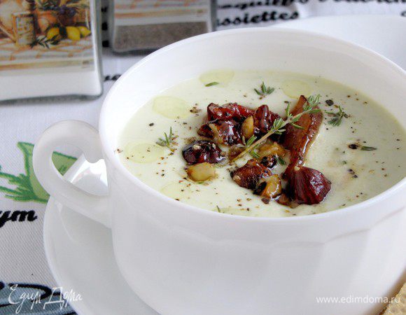 Сырный суп подавать с карамелизованными ломтиками свинины, семенами подсолнуха и фундуком, сбрызнув оливковым маслом.