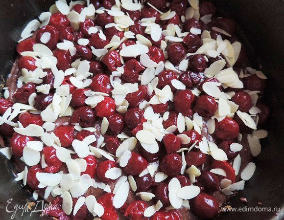 Выкладываем тесто в форму диаметром 23см, дно которой выстилаем бумагой. Сверху выкладываем свежую или размороженную вишню без косточек (при разморозке сок слить, он нам пригодится). Посыпаем миндальными лепестками.