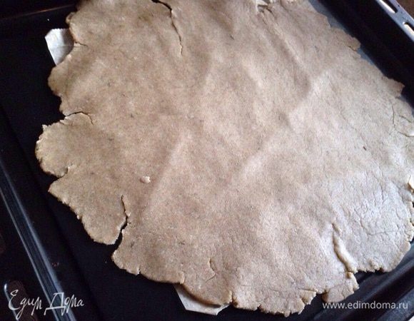 Тесто тонко раскатать на присыпанной мукой рабочей поверхности. Потом аккуратно перенести на противень застеленный бумагой для выпечки.