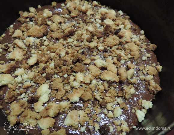 Выкладываем тесто в форму 24 см, дно которой выстелено бумагой. Сверху посыпаем штрейзелем.