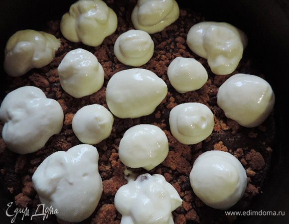 Застывающий крем перекладываем в кондитерский мешок с круглой насадкой. Испеченный остывший бисквит вынимаем из формы и возвращаем назад. Сверху на бисквит отсаживаем шарики из белого крема побольше и поменьше. Убираем в морозилку, чтоб они хорошо затвердели.