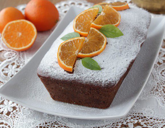 Готовому кексу дать остыть в форме 10-15 минут, затем аккуратно вынуть и остудить полностью.
Посыпать сахарной пудрой, украсить дольками апельсина.