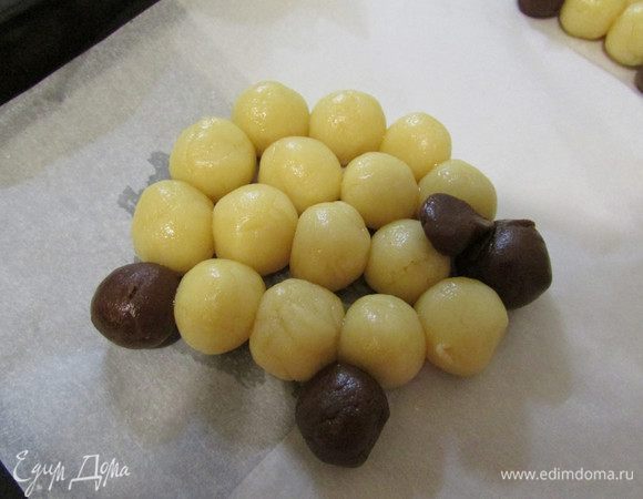 Из теста сформировать овечек. Для этого белое тесто отщипывать небольшими кусочками и скатывать шарики. Сформировать из шариков туловище, а из шоколадного теста — голову, ухо и ноги. 