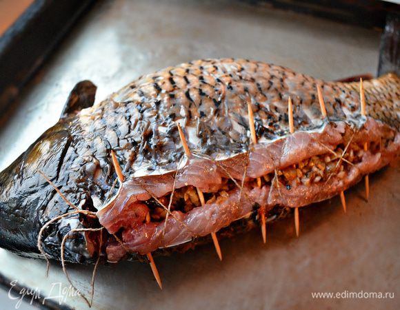 С помощью металлических, а если нет - деревянных шпажек, зубочисток соединяем рыбу. А кулинарной нитью делаем "шнуровку", слегка подтягивая нить,  завязываем концы. Смазываем поверхность противня и самого карпа растительным маслом. Выкладываем карп на противень и запекаем 10 мин в нагретой до 220г духовке. Затем убавляем жар до 180г и готовим ещё 30-40 мин. Таким образом поверхность рыбы получится с красивой румяной корочкой, а внутри рыба будет сочной.