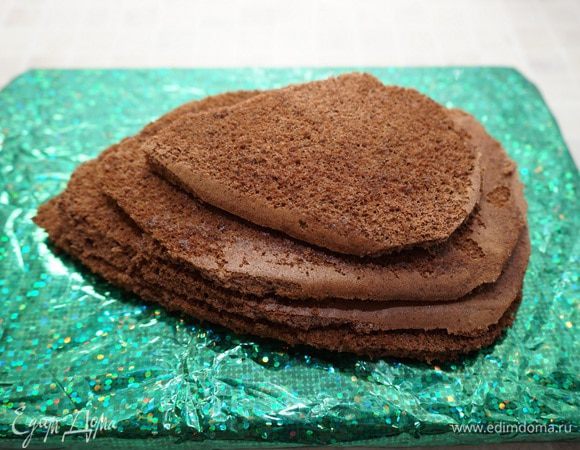 Сложить коржи друг на друга, держа нож под углом срезать излишки бисквита так, чтоб образовалось подобие шишки.