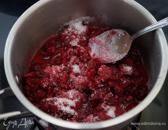 Я решила разбавить сладость торта и привнести зимние нотки и добавила слой из клюквенного желе. Для этого в  сотейнике клюкву засыпать сахаром, довести до кипения, немного проварить. Снять с огня. 