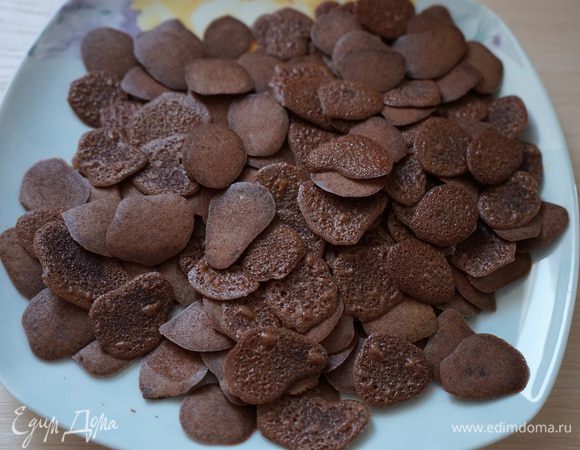 Испечь шоколадные чипсы по рецепту http://www.edimdoma.ru/retsepty/40343-shokoladnye-chipsy-s-mindalem.  Указанной в том рецепте порции как раз хватило на весь торт. У меня получилось 5 или 6 противней. 
Аккуратно вставить в крем шоколадные чипсы, причём я их приклеивала той стороной вверх, что лежала на противне. На них от тефлонового листа образовался мелкий сетчатый рисунок – очень подошёл. 