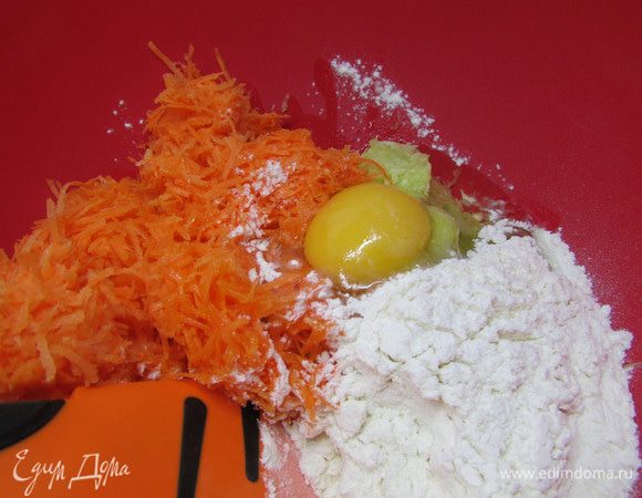 Кабачки и морковь хорошо отжать от сока. В миске соединить овощи, добавить яйцо, растительное масло и муку. Замесить тесто.