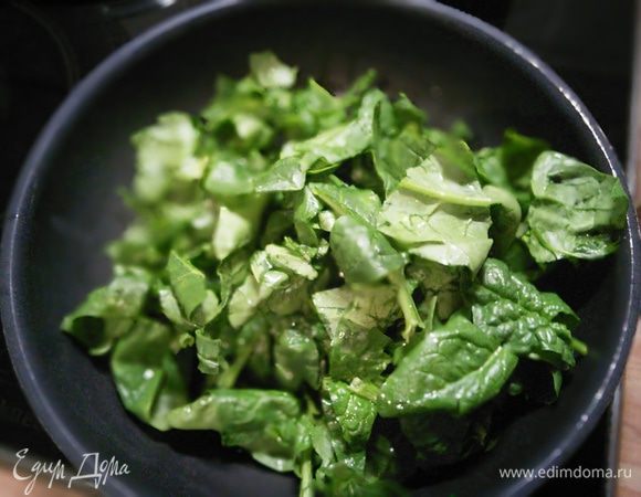 На разогретом оливковом масле пассировать мелко нарезанный чеснок, добавить порционно шпинат, когда он "опадёт" посолить, поперчить и добавить мускатный орех. 