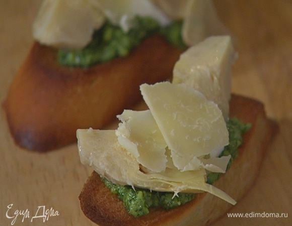 Пармезан нарезать тонкими хлопьями и посыпать брускетты.