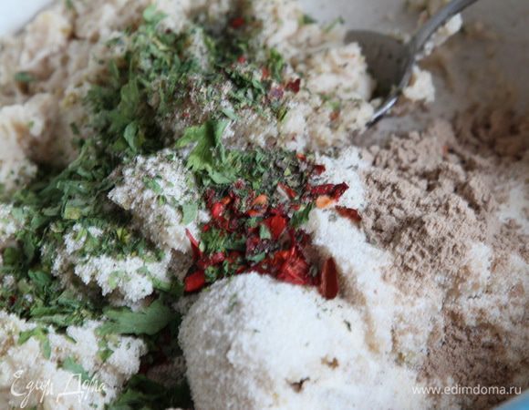 В фарш добавляем лепестки паприки и чили, 1 столовую ложку сушеной петрушки, щепотку сушеного базилика, 2 столовые ложки манки, 1 чайную ложку льняной муки и чуть-чуть воды, чтобы можно было хорошо вымесить фарш.