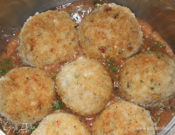 В сотейник выкладываем немного соуса, затем в один слой выкладываем фрикадельки.