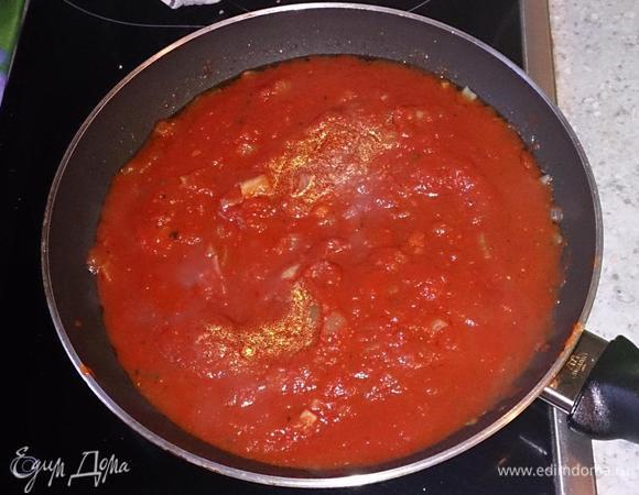 Готовим начинку. Для этого лук и чеснок мелко режем и обжариваем в оливковом масле. Добавляем томат-пасту и помидоры консервированные, приправляем солью, перцем, сахаром и чили. Продолжаем проваривать на среднем огне 20 минут. Масса загустеет.