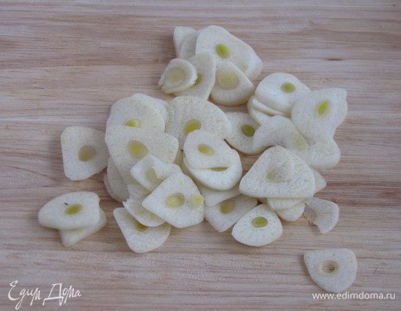 Зубчики чеснока нарезать очень тонкими пластинками.