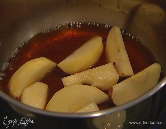Оставшийся сахар всыпать в небольшую кастрюлю, влить 3 ст. ложки воды, добавить дольки яблок и закарамелизировать их.