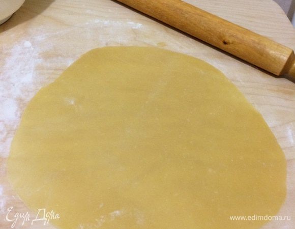 Тесто выложить на рабочую поверхность и вымешать в однородную массу, которая не прилипает к рукам. Далее поделить на 6–7 частей. Раскатать тесто, разрезать на коржи.