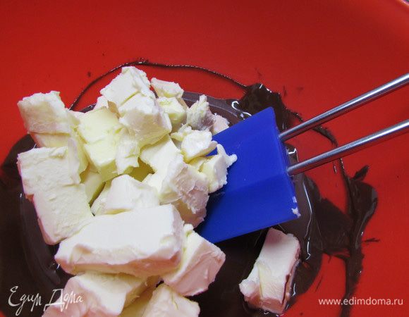 Добавить масло, нарезанное маленькими кусочками. Как только масло растопилось, убрать с бани.