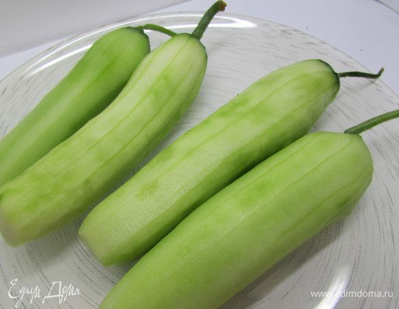 Свежие огурцы помыть, обсушить. Снять тонким слоем кожицу с помощью овощечистки.