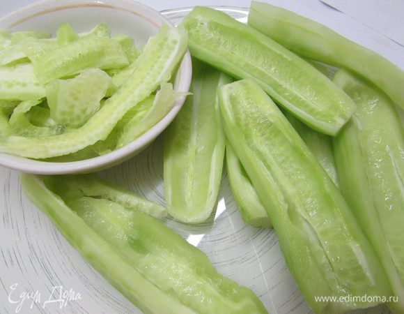 Огурчики разрезать пополам и удалить семена.