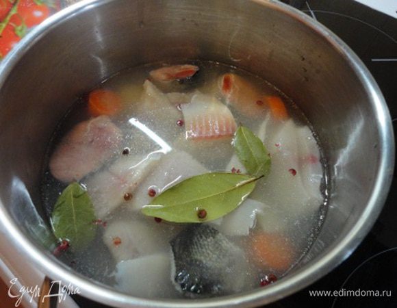 Аккуратно шумовкой выложите кусочки рыбы в кастрюлю, добавьте перец горошком ( я люблю использовать красный перец для рыбы), лавровый лист и соль по вкусу. Бульон должен быть слегка пересоленным, если этого не сделать, то после охлаждения бульон будет на вкус недосоленным. Варить около 20 минут, снимая пену и не давая бульону сильно кипеть.