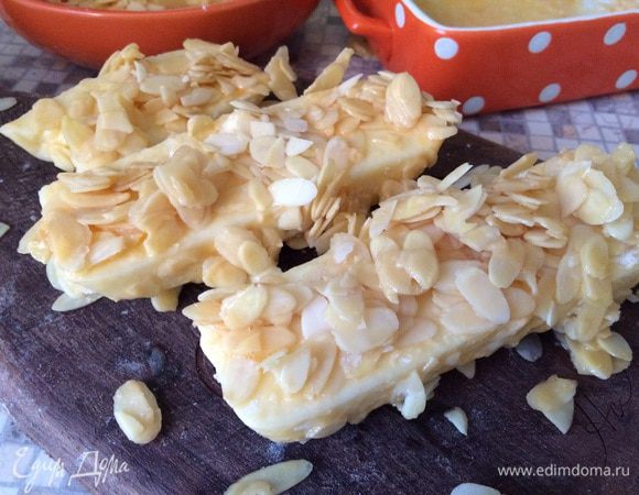 Затем купаем напудренный сыр в слегка взбитых яйцах и обваливаем в миндальных лепестках. Жирно от души обваливаем, а кому на Новый год в платье не в влезать, оно с вас сваливается и вообще... можно второй экстра слой сделать, еще раз в яйца и миндаль. Что то будет соскальзывать  - не переживайте, Все в порядке. 